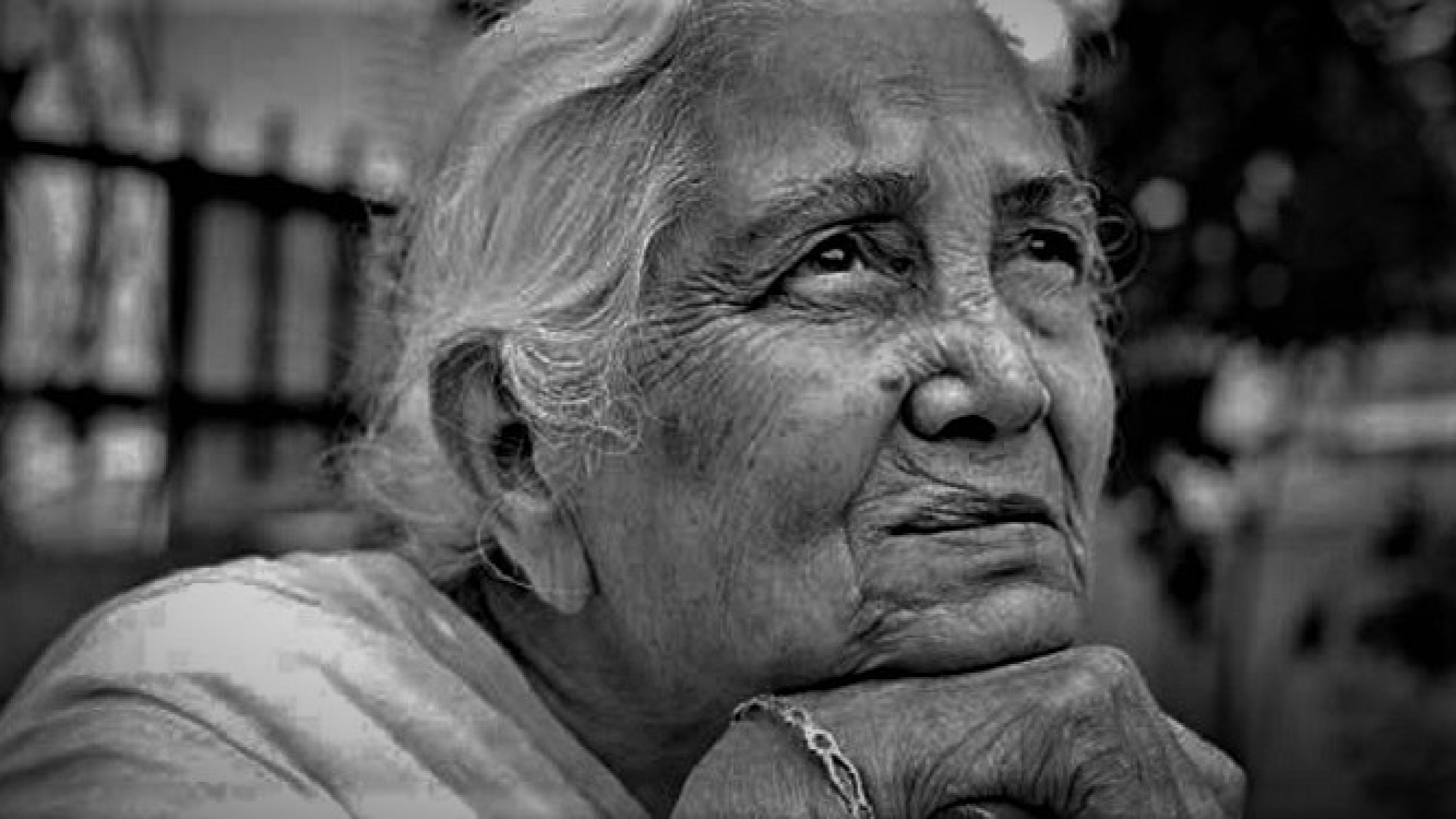 One sad pensive senior Indian woman looking up