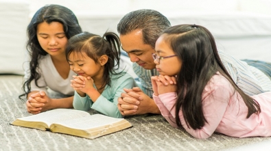 Family reading the Bible together in their living room.