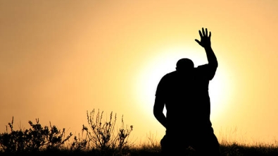 A man lifts his hand towards heaven. Silhouette, rear view, unrecognizable person. Additional themes include salvation, god, praise and worship, holiness, righteousness, faith, sin, forgiveness, gratitude, meditation, prayer, self, asking, pleading, hope, heaven, healing, spirituality, balance, religious, and Christianity.